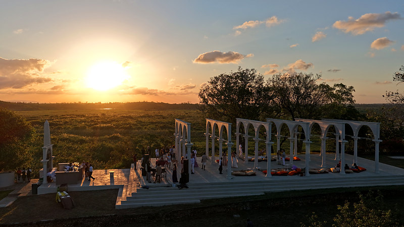 Guests gathering in the temple at sunset over the valley