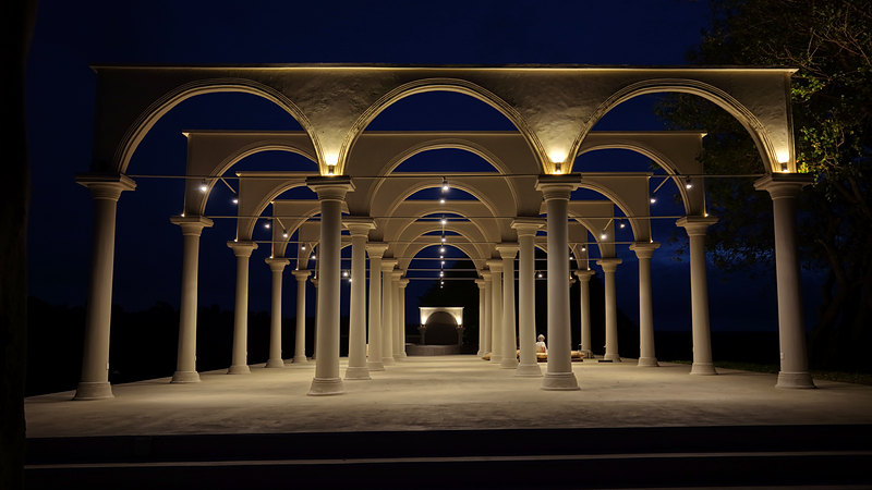 Inside the temple, rows of lit columns at night