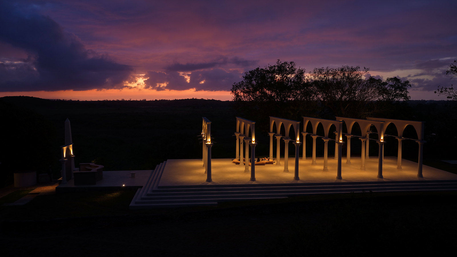 The temple lit at twilight under a purple sky